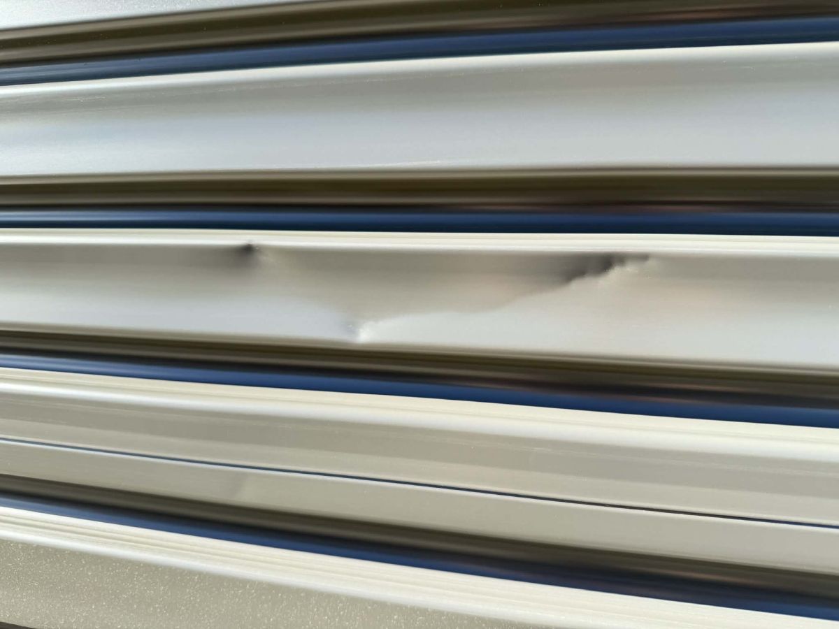 Garage roller door dent before repair Hobart