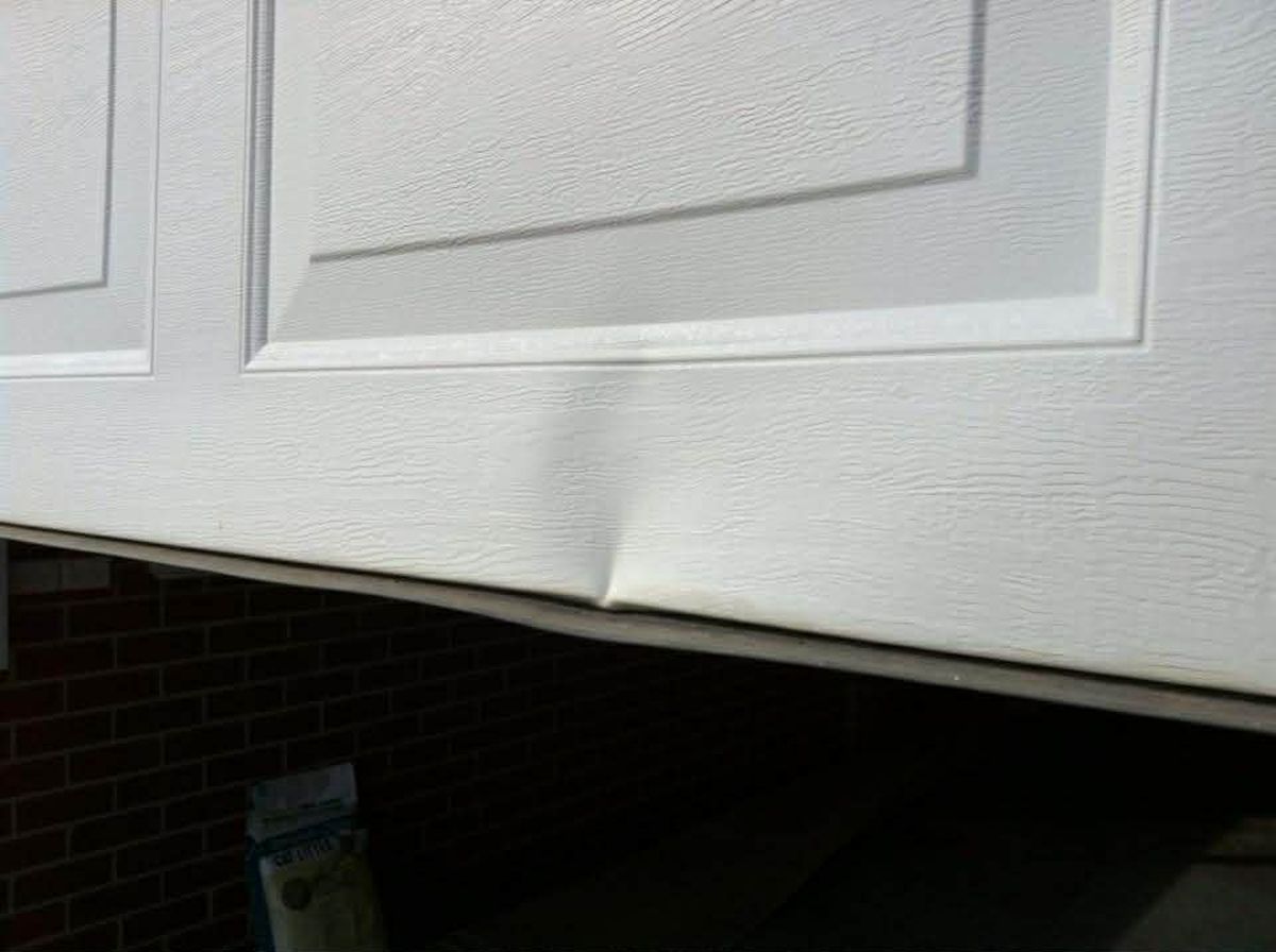 Garage roller door dent before repair Hobart