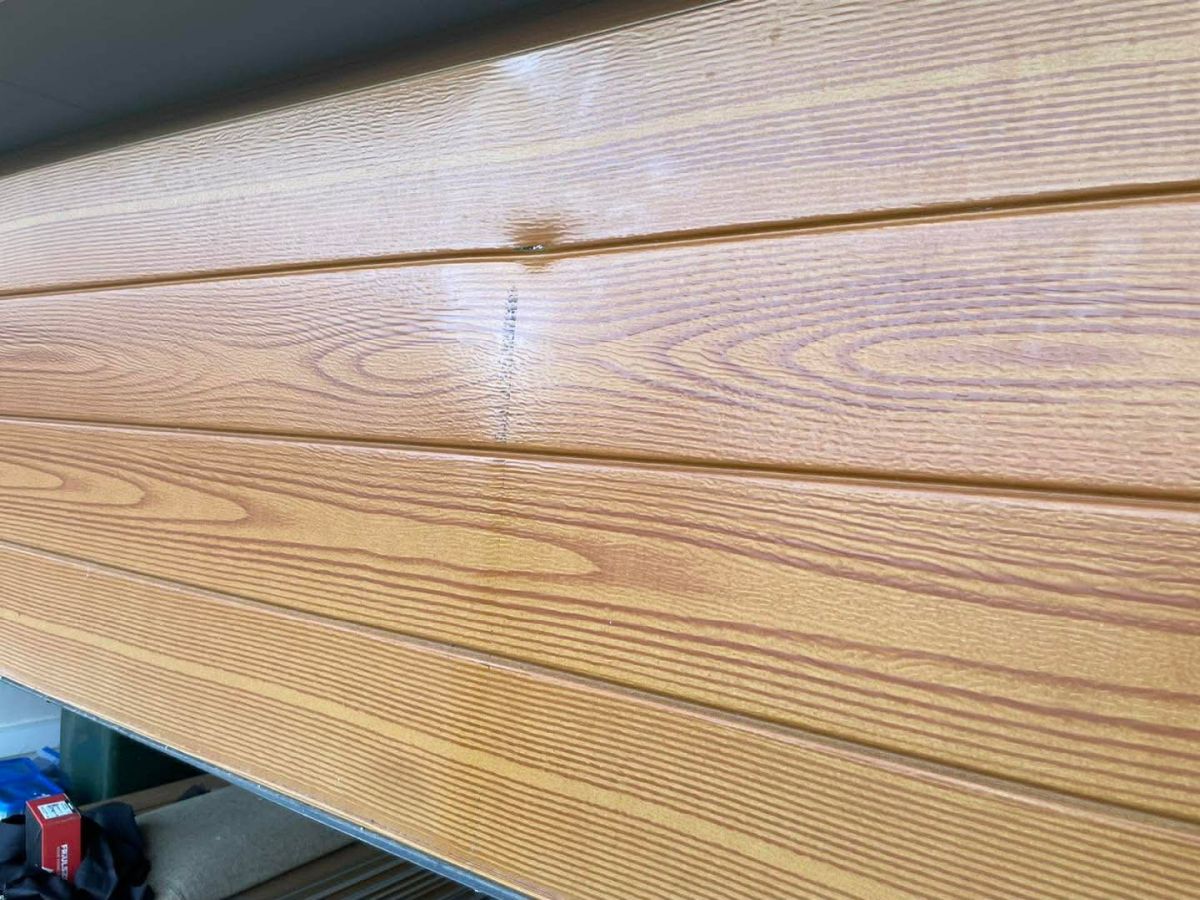 Garage roller door dent before repair Hobart