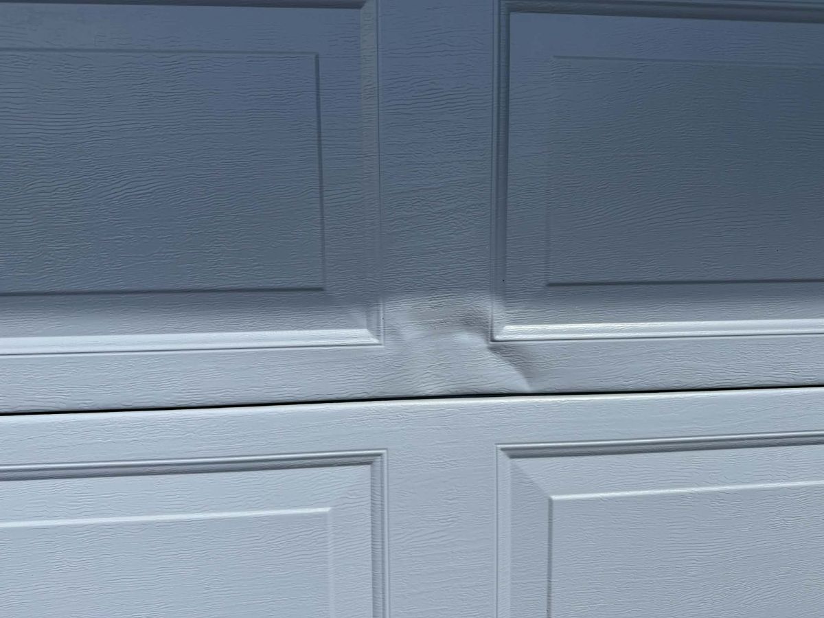 Garage roller door dent before repair Hobart